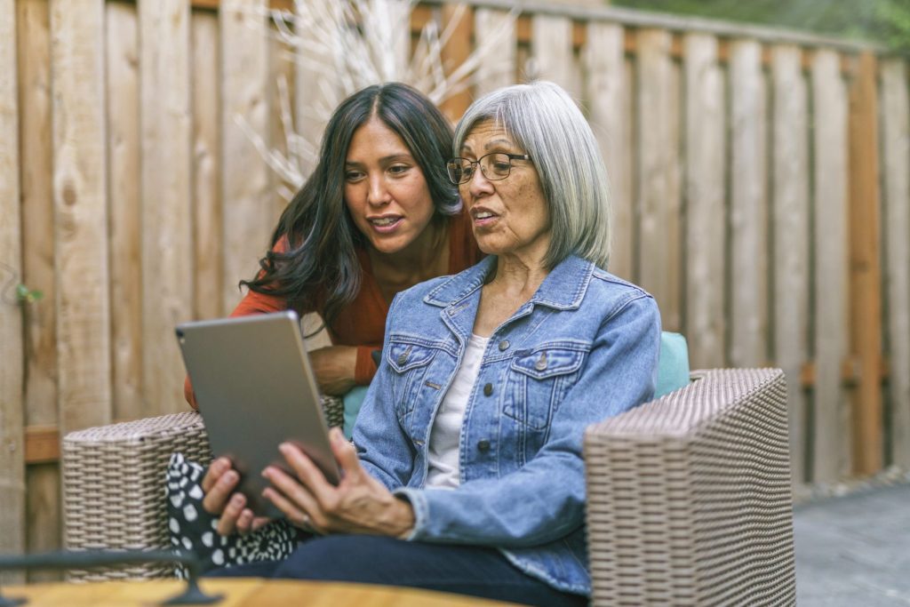 Senior woman learning to use tablet computer with the help of her adult daughter | Sunny Vista Senior Living Colorado Springs