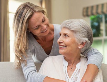 Memory Care Colorado Springs Daughter hugging mother on couch